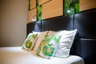 a bed with two pillows and a black head board at Hotel Allur in Plovdiv