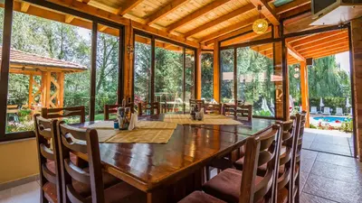 a dining room with a large wooden table and chairs at Family Hotel Iv in Velingrad