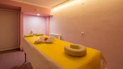 a yellow bed with a bow on top of it at Family Hotel Iv in Velingrad