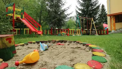 a sandbox in a park with a playground at Family Hotel Iv in Velingrad