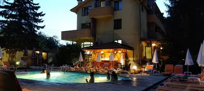 a hotel with a swimming pool with people sitting in it at Family Hotel Iv in Velingrad