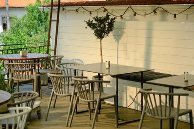 a group of tables and chairs on a patio at Family Hotel Ramira in Kyustendil