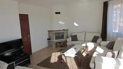 a living room with a couch and a fireplace at Amampuri Village in Pamporovo