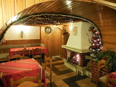 a restaurant with a christmas tree and a fireplace at Boyadjiyski Guest House in Bansko