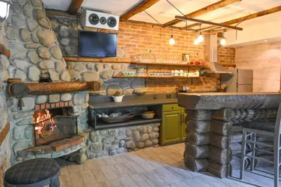 a kitchen with a stone wall and a fireplace at Klecherova House in Bansko