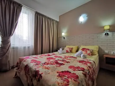 a bedroom with a large bed with red flowers on it at Zigen House in Bansko
