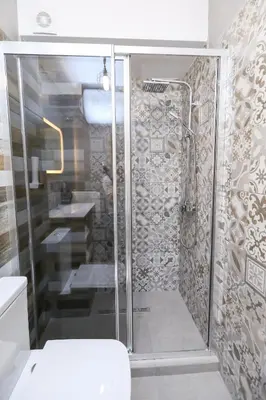 a bathroom with a shower with a glass door at Artemis Apartments in Sandanski