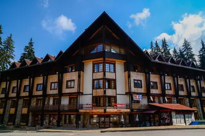 a large building with a gambrel roof at Апартаменти Малина in Pamporovo