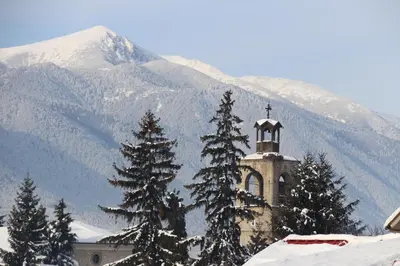 a church with a cross on top of a mountain at Hotel Alpin - 91 Bansko in Bansko