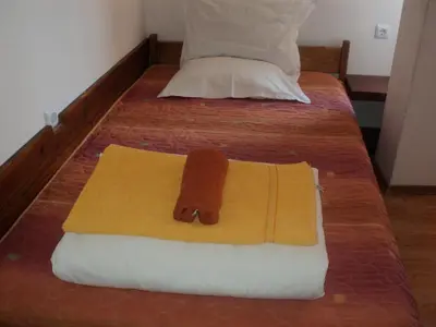 a bed with a towel on top of it at Hotel Alpin - 91 Bansko in Bansko