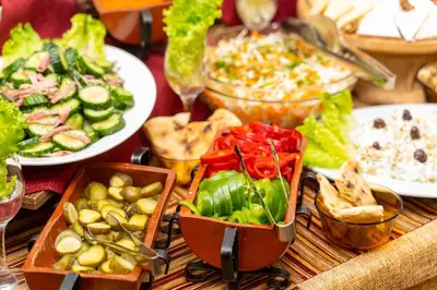 a table topped with plates of food and bowls of vegetables at MPM Family Hotel Merryan in Pamporovo