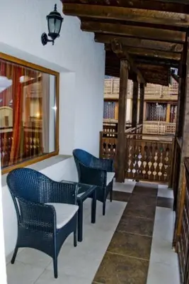 a library with three chairs and a window with books at Guest House Chicho Tsane in Bansko