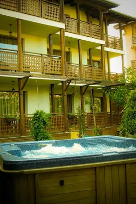 a building with a jacuzzi in front of a building at Guest House Chicho Tsane in Bansko