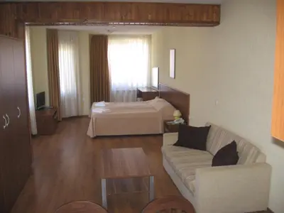 a living room with a couch and a bed at Apart Hotel Comfort in Bansko