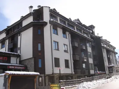 a large white building with snow on the ground at Apart Hotel Comfort in Bansko