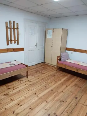 a room with two beds and a wooden floor at Sky Rooms in Sofia
