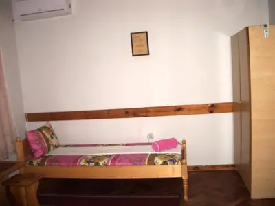 a small bed in a room with a wall at Sky Rooms in Sofia