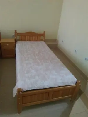 a bedroom with a wooden bed with a white mattress at ИВАНЕЛИ in Sapareva Banya
