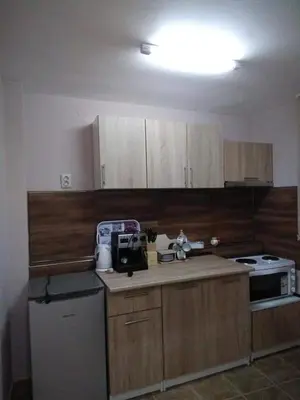 a kitchen with wooden cabinets and a stove top oven at ИВАНЕЛИ in Sapareva Banya