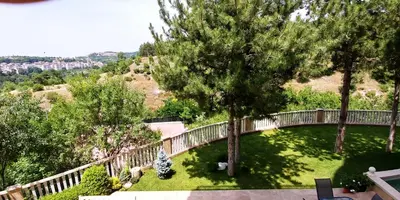 a view of a garden with a bridge and trees at Garden Guest House in Sandanski