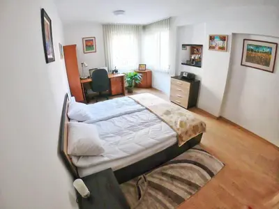 a bedroom with a large bed and a desk at Art31 in Sofia