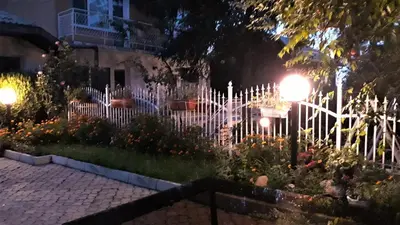 a white picket fence in front of a house at night at Andro Apartments in Sofia