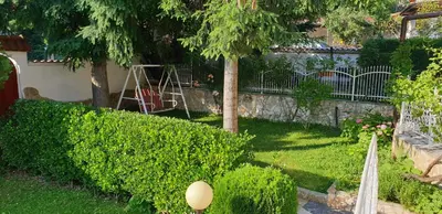 a garden with bushes and trees and a fence at Andro Apartments in Sofia