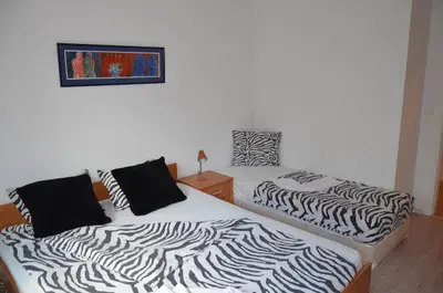 two beds in a bedroom with zebra print sheets at Bulhotel Pritzker Apartment in Sofia