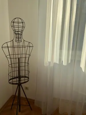 a wire mannequin sitting in front of a window at Apartment August 11 in Sofia