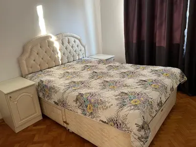 a bedroom with a bed with a floral bedspread at Apartment August 11 in Sofia