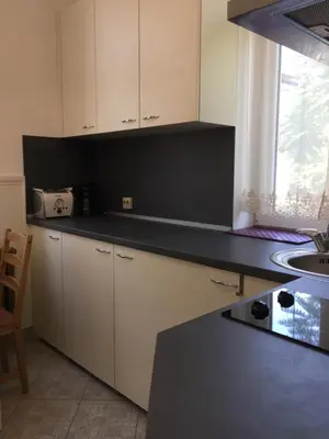 a kitchen with white cabinets and a black counter top at Apartment August 11 in Sofia