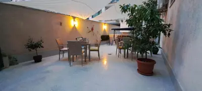 a patio with a table and chairs and a plant at Central West Hotel in Sofia