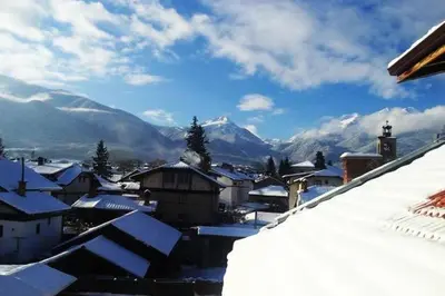 a snow covered village with mountains in the background at Family House Oreha in Bansko
