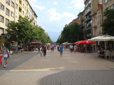 a group of people walking down a street with buildings at Solunska Apartment in Sofia