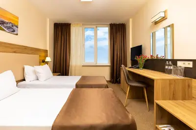 a hotel room with a bed and a desk at Hotel Intelcoop in Plovdiv
