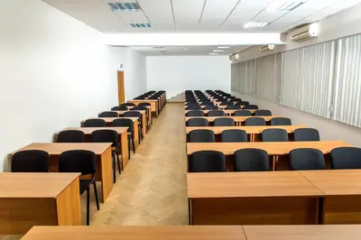 an empty lecture room with desks and chairs at Hotel Intelcoop in Plovdiv