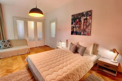 a bedroom with a large bed and a couch at TERRACE HOME - Three bedrooms City center in Plovdiv