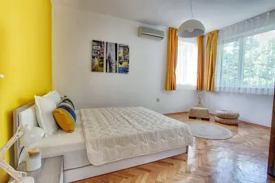 a bedroom with a bed in a room with yellow walls at TERRACE HOME - Three bedrooms City center in Plovdiv