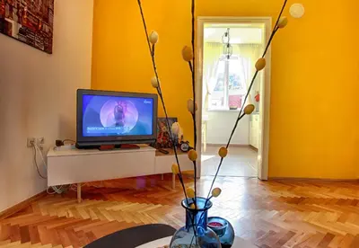 a living room with a tv and a vase with flowers at TERRACE HOME - Three bedrooms City center in Plovdiv