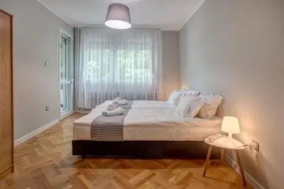 a bedroom with a large bed and a window at Spacious flat close to the American Embassy, free parking place in Sofia
