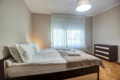 a bedroom with a large bed and a window at Spacious flat close to the American Embassy, free parking place in Sofia