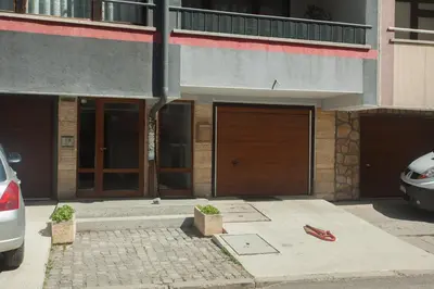 a building with two garage doors on a street at Spacious flat close to the American Embassy, free parking place in Sofia