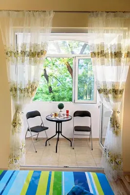 a room with a table and chairs and a window at Apartment Iris in Plovdiv