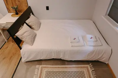 a small bed with two white towels on it at Vinyl Studio Apartment Sofia in Sofia