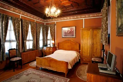a bedroom with a bed and a chandelier at Old Legends Hotel in Plovdiv