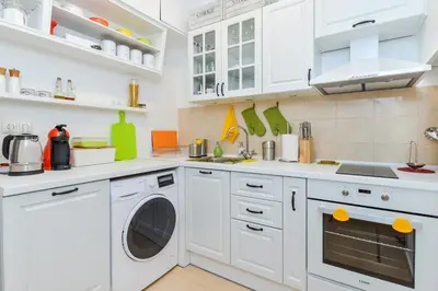 a white kitchen with white cabinets and a washer and dryer at The Charming Home - One Bedroom TOP Central Apartment by Flat Mаnager in Sofia