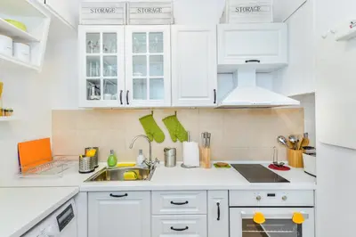 a white kitchen with white cabinets and a sink at The Charming Home - One Bedroom TOP Central Apartment by Flat Mаnager in Sofia