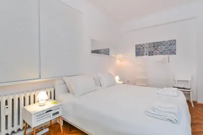 a white bedroom with a white bed and a table at The Charming Home - One Bedroom TOP Central Apartment by Flat Mаnager in Sofia