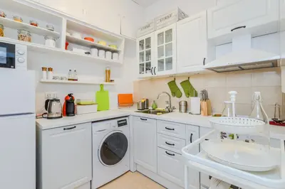 a kitchen with white cabinets and a washer and dryer at The Charming Home - One Bedroom TOP Central Apartment by Flat Mаnager in Sofia