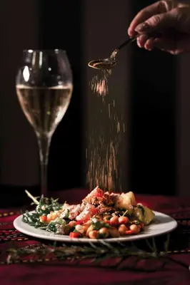 a plate of food on a table with a glass of wine at Royal Park Hotel by Astoria Collection in Bansko